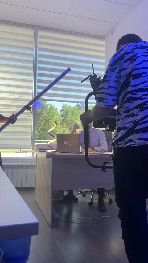 Operator coordinates angle as suited man sits by window Stock Footage 313865465