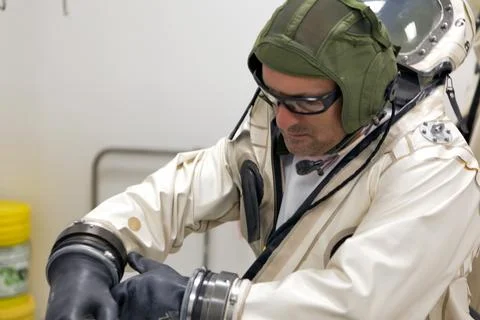 An operator dons a Self-Contained Atmospheric Protective Ensemble (SCAPE) s.. Stock Photos