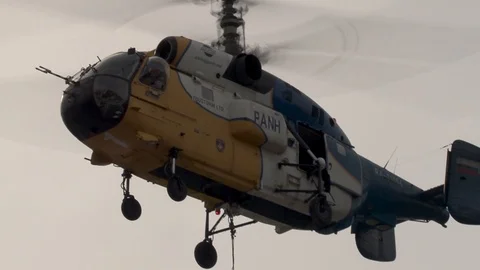 Operator in doorway of side door Ka-32 helicopter at installation of cableway. Stock Footage 106771867
