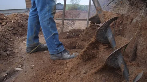 Operator drills near stump, operator skillfully uses gaspowered auger to clear Stock Footage 319692391