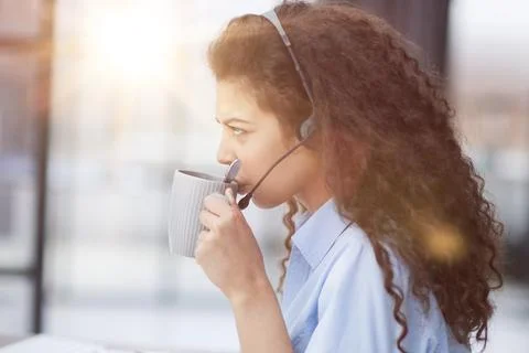 The operator enjoys fragrant coffee, taking a short break from work 스톡 사진