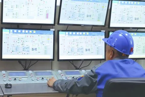 The operator of the equipment control panel at LNG plant sits behind the mo.. Stock Photos