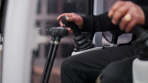 Operator hand controlling joystick inside industrial vehicle cabin Stock Footage 326825470