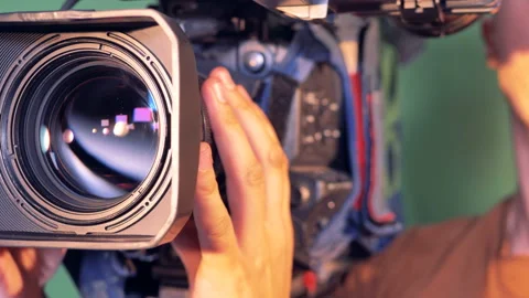 Operator is holding a video camera, turning it thereafter it is zooming out Stock Footage