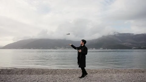 Operator holds control panel of the quadcopter against background of mountains Stock Footage 250422916