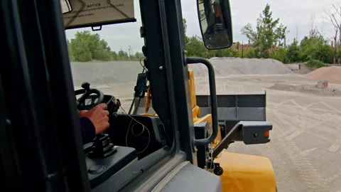 Operator inside a construction vehicle cabin, controlling the machinery at a Stock Footage 287264882