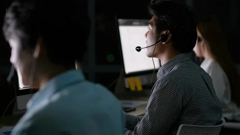 Operator man work together with his team to support the customer at night Stock Footage 124544432