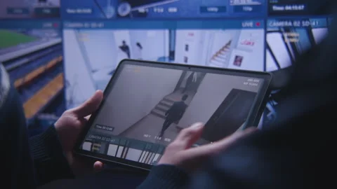 Operator monitors CCTV cameras using tablet Video stock 240478159