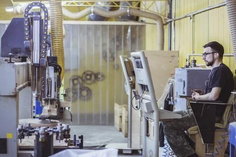 Operator observes the work of the CNC machine Stock Photos