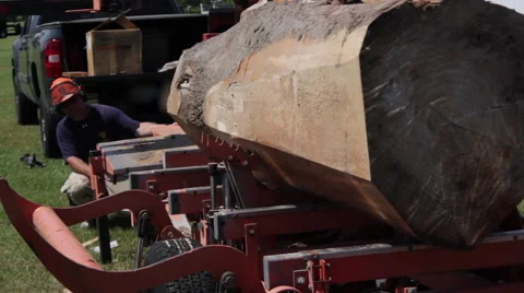 Operator positions large log on portable sawmill Stock Footage 40472212