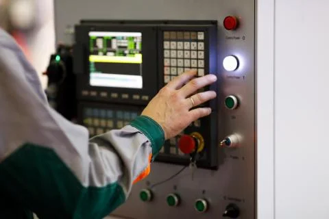 Operator programs the CNC manufacturing machine Stock Photos