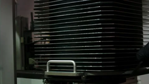 Operator pulls out a stack of newly pressed vinyl records as part of an Stock Footage 303648784