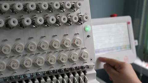 The operator sets up the cnc machine. A worker is programming a sewing machine 库存影片 119543892