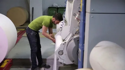 The operator sets up a roll of newsprint in the printing press. Print the newspa Stock-Footage 75451957