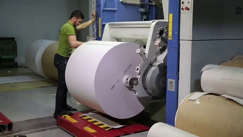 The operator sets up a roll of newsprint in the printing press. Print the newspa Stock-Footage 75452062