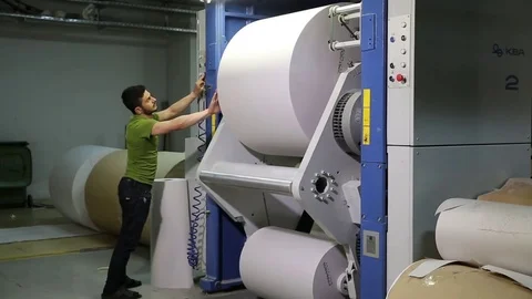 The operator sets up a roll of newsprint in the printing press. Print the newspa Stock Footage 75452092