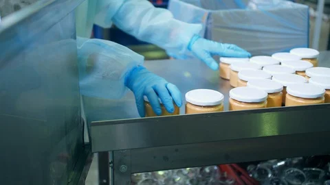 The operator at the soybean processing plant stacks glass jars with paste from Video stock 127652032