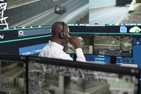 Operator speaking in headset microphone while monitoring traffic feeds Stock Photos