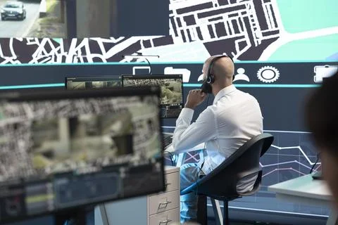 Operator speaks in headset mic and monitors urban traffic Stock Photos