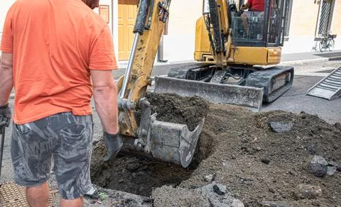 Operator supervising excavator while digging in Construction Area Stock Photos