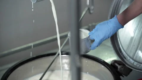 Operator Taking a Sample of Processed Milk from a Tank. Pouring it into a Cup Stock Footage 251139680
