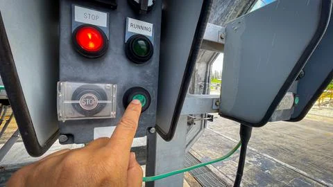 Operator technician hand pressing the start button on a local control switc.. Stock Photos