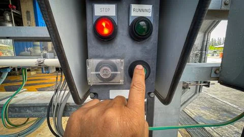 Operator technician hand pressing the start button on a local control switc.. Stock Photos