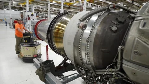 Operator towing aeroplane engine part at engine overhaul facility Stock Footage 231690668