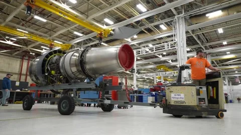 Operator towing aircraft engine part at engine overhaul facility Stock Footage 231690663