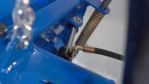 The operator on the tractor raises the bucket. Hydraulic pistons moving forward Stock Footage 128631086