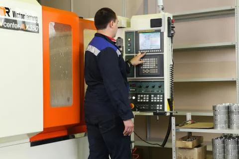 Operator uses control display for managing lathe cnc machine. Fotos de archivo