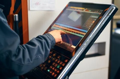 Operator uses the LCD touch screen to control adjust parameter of CNC lathe Stock Photos