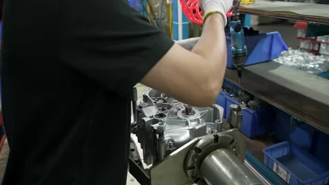 Operator Uses Pneumatic Screwdriver To Assemble Motor Part At Factory Stock Footage 337524806