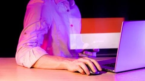 Operator using devices with overlaid multi-striped banner in vibrant setup Stock Photos
