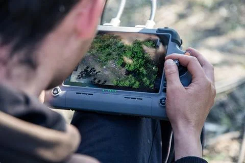 Operator using drone remote controller with connected cables Фото
