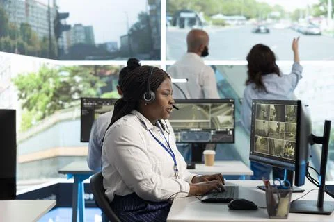 Operator wearing audio headset inspecting traffic incidents on displays Stock Photos