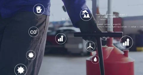 Operator wearing blue jacket pushing red drum on cart across warehouse floor, Stock Photos