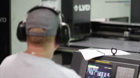 Operator working with a CNC turret punch press Stock Footage 317253617