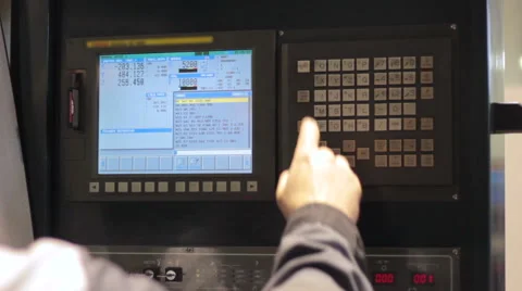 Operator working with control panel of CNC machining centerchanging numbers Vidéo 60235482