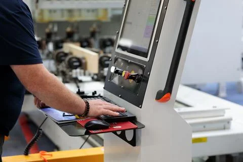 Operator works at control panel of CAD CAM machine Stock Photos