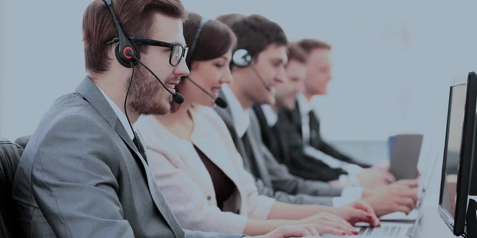 Operators with headsets in front of computers in the call center Stock Photos