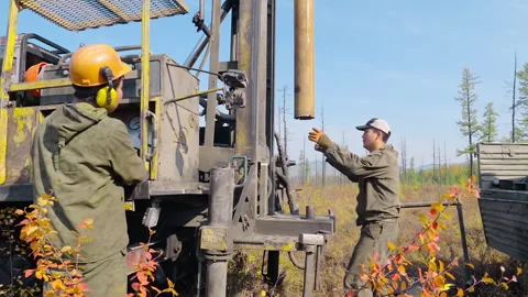 Operators Insert Drill Bit In Rig For Gold Deposit Location Сonfirmation Video stock 303579480