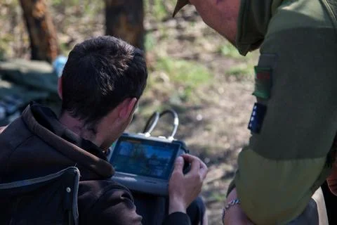 Operators using drone remote controller with connected cables Фото