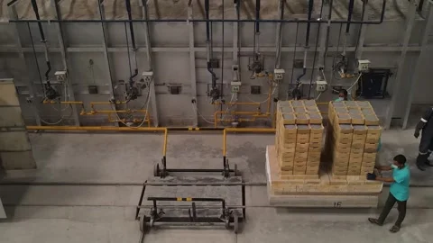 Operators working to a tunnel kiln on a train to heat ceramic balls in a factory Stock Footage 250218273
