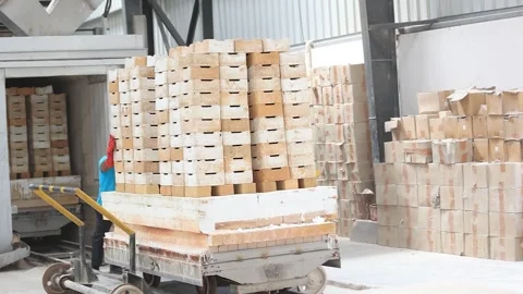 Operators working to a tunnel kiln on a train to heat ceramic balls in a factory Stock Footage 250543652