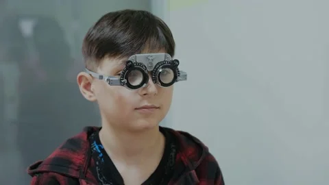 Ophthalmologist examining little boy inserting a lens into lens testing eye Stock Footage 237945778