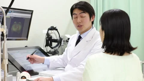 Ophthalmologist Explaining Eye Test Results to Female Patient in Clinic Vídeos de archivo 344238419