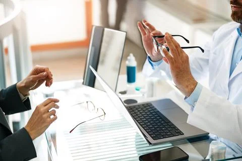 Ophthalmologist offers the client to replace the old spectacle frame with a Foto stock