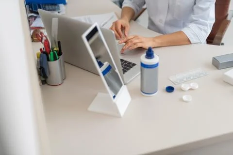 Ophthalmologist using notebook and preparing contact lenses for patient Stock Photos