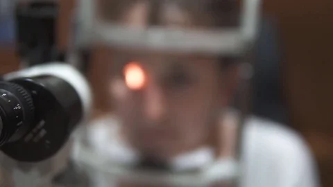 Ophthalmology machine and blurred head for checking eye, closeup Stock Footage 77118982